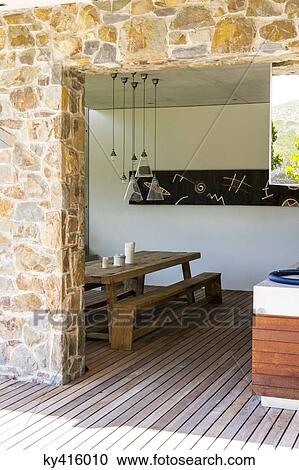 Stock Image - Picnic table and bench in a porch. Fotosearch