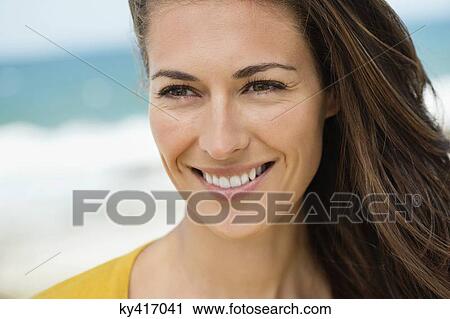 Close-up of a woman smiling on the beach View Large Photo Image Stock Image - Close-up of a woman smiling on the beach. Fotosearch