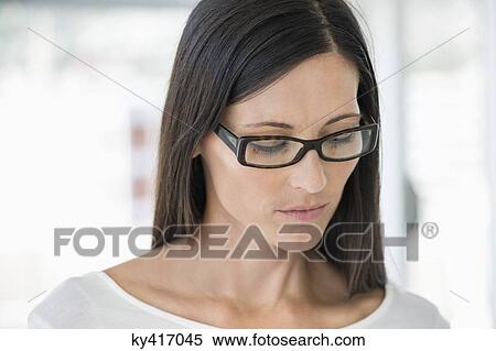 Close-up of a woman wearing eyeglasses View Large Photo Image Stock Photography - Close-up of a woman wearing eyeglasses. Fotosearch