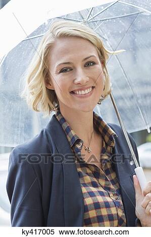 Portrait of a smiling woman with an umbrella View Large Photo Image Stock Photography - Portrait of a smiling woman with an umbrella. Fotosearch