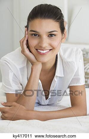 Portrait of a woman smiling on the bed View Large Photo Image Stock Image - Portrait of a woman smiling on the bed. Fotosearch