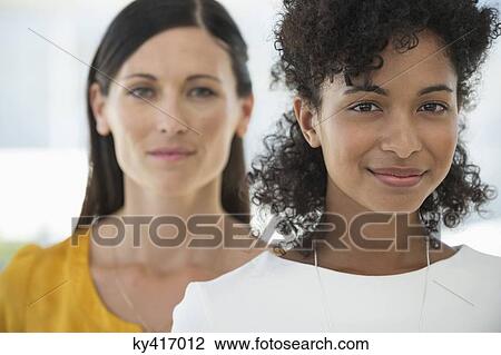 Stock Image - Portrait of two female friends smiling together. Fotosearch