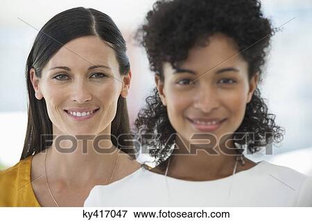 Stock Photo - Portrait of two female friends smiling together. Fotosearch