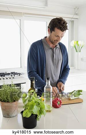 Man chopping vegetables in a kitchen View Large Photo Image Stock Photography - Man chopping vegetables in a kitchen. Fotosearch