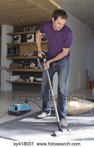 Man cleaning living room with vacuum cleaner View Large Photo Image Stock Image - Man cleaning living room with vacuum cleaner. Fotosearch