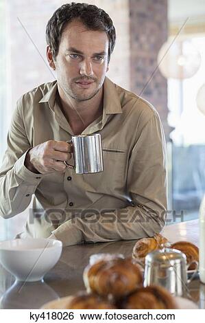 Stock Photograph - Man drinking tea in the kitchen. Fotosearch