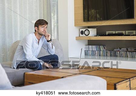 Man sitting in a living room and thinking View Large Photo Image Stock Image - Man sitting in a living room and thinking. Fotosearch