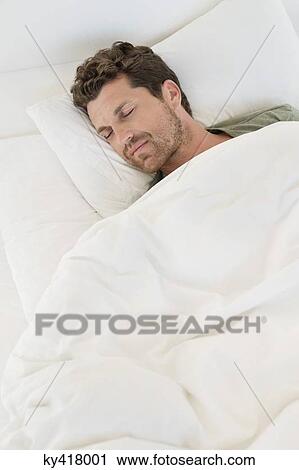 Man sleeping on the bed View Large Photo Image Stock Image - Man sleeping on the bed. Fotosearch