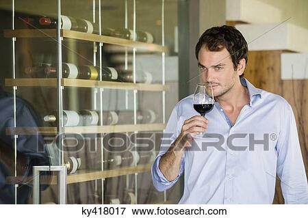 Stock Photo - Man smelling red wine in a wineglass. Fotosearch