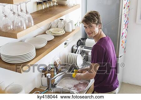 Man washing dishes in his kitchen View Large Photo Image Picture - Man washing dishes in his kitchen. Fotosearch