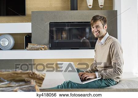 Stock Photograph - Portrait of a smiling man using a laptop. Fotosearch