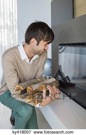 Smiling man carrying firewood View Large Photo Image Stock Photo - Smiling man carrying firewood. Fotosearch
