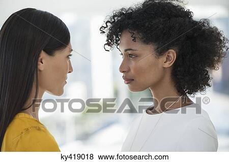 Close-up of two female friends looking at each other View Large Photo Image Stock Photo - Close-up of two female friends looking at each other. Fotosearch