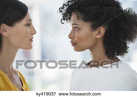 Close-up of two female friends looking at each other View Large Photo Image Stock Photo - Close-up of two female friends looking at each other. Fotosearch