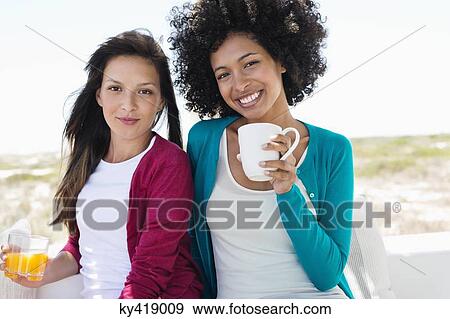 Portrait of a two female friends smiling View Large Photo Image Stock Photo - Portrait of a two female friends smiling. Fotosearch