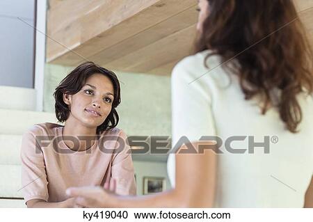 Two female friends discussing at home View Large Photo Image Stock Image - Two female friends discussing at home. Fotosearch