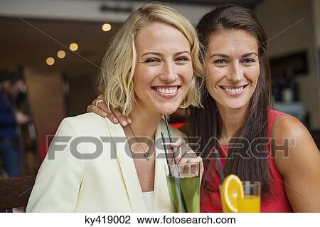 Two female friends enjoying drinks in a restaurant View Large Photo Image Stock Image - Two female friends enjoying drinks in a restaurant. Fotosearch