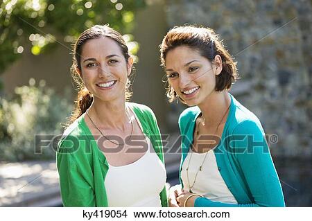 Two female friends smiling together View Large Photo Image Picture - Two female friends smiling together. Fotosearch