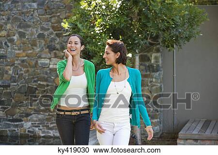 Two female friends smiling together View Large Photo Image Stock Image - Two female friends smiling together. Fotosearch