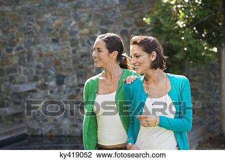 Two female friends smiling together View Large Photo Image Stock Image - Two female friends smiling together. Fotosearch