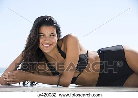 Beautiful woman in bikini lying on the beach and smiling View Large Photo Image Stock Image - Beautiful woman in bikini lying on the beach and smiling. Fotosearch