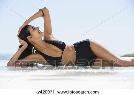 Beautiful woman in bikini posing on the beach View Large Photo Image Stock Image - Beautiful woman in bikini posing on the beach. Fotosearch