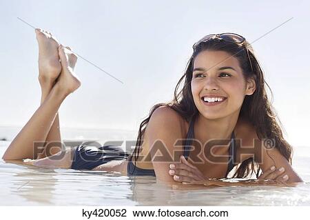 Stock Image - Beautiful woman lying on the beach. Fotosearch