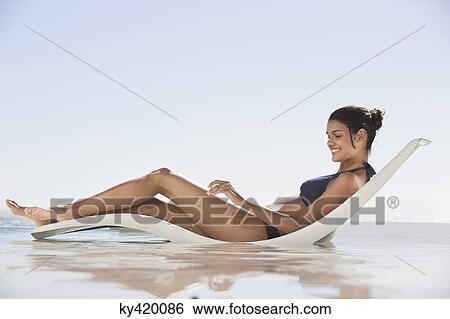 Beautiful woman sunbathing on the beach View Large Photo Image Stock Photograph - Beautiful woman sunbathing on the beach. Fotosearch