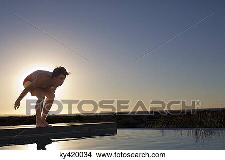 Man about to jump into a swimming pool View Large Photo Image Picture - Man about to jump into a swimming pool. Fotosearch
