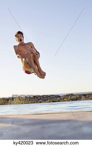 Man jumping into a swimming pool View Large Photo Image Stock Image - Man jumping into a swimming pool. Fotosearch