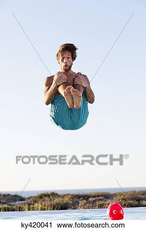 Man jumping into a swimming pool View Large Photo Image Stock Image - Man jumping into a swimming pool. Fotosearch
