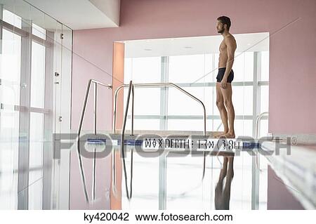 Man standing at the poolside View Large Photo Image Stock Image - Man standing at the poolside. Fotosearch