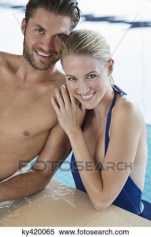 Stock Photography - Smiling couple at the poolside. Fotosearch