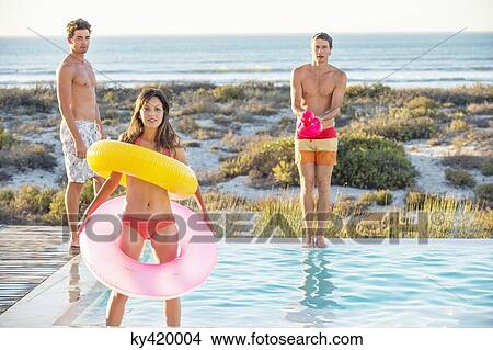 Three friends enjoying at a swimming pool on the beach View Large Photo Image Picture - Three friends enjoying at a swimming pool on the beach. Fotosearch
