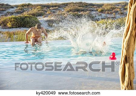 Two male friends enjoying in a swimming pool on the beach View Large Photo Image Stock Photo - Two male friends enjoying in a swimming pool on the beach. Fotosearch