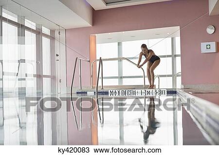 Stock Image - Woman diving into a swimming pool. Fotosearch