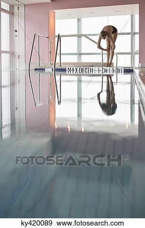 Woman diving into a swimming pool View Large Photo Image Stock Photo - Woman diving into a swimming pool. Fotosearch