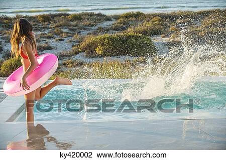 Woman enjoying in a swimming pool on the beach View Large Photo Image Stock Image - Woman enjoying in a swimming pool on the beach. Fotosearch