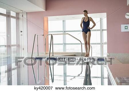 Woman standing at the poolside with hands on hips View Large Photo Image Stock Photo - Woman standing at the poolside with hands on hips. Fotosearch