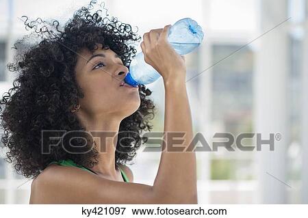 Close-up of a woman drinking water from a bottle View Large Photo Image Stock Photo - Close-up of a woman drinking water from a bottle. Fotosearch