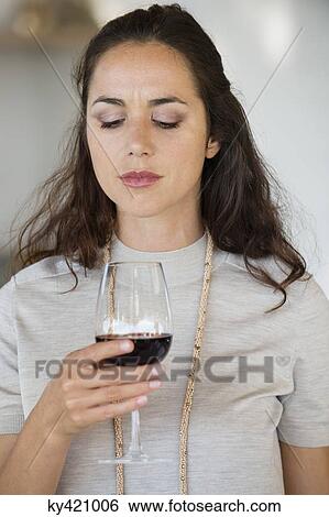 Close-up of a woman holding a wine glass View Large Photo Image Stock Photograph - Close-up of a woman holding a wine glass. Fotosearch