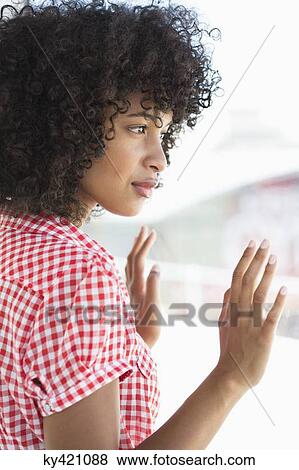 Stock Photo - Close-up of a woman looking out of a window. Fotosearch