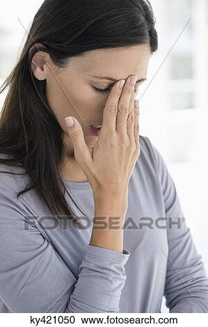 Stock Image - Close-up of a woman suffering from a headache. Fotosearch