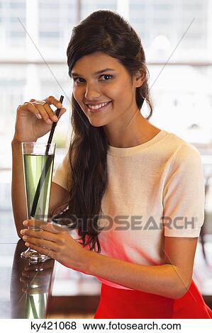 Portrait of a smiling woman drinking cocktail View Large Photo Image Stock Photo - Portrait of a smiling woman drinking cocktail. Fotosearch