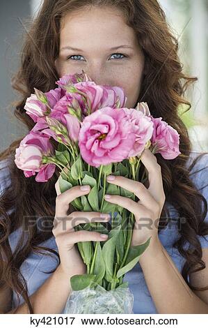 Portrait of a woman holding a bouquet of flowers View Large Photo Image Stock Photo - Portrait of a woman holding a bouquet of flowers. Fotosearch