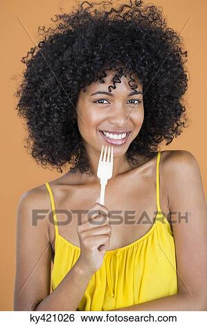 Portrait of a woman holding a fork and smiling View Large Photo Image Stock Photograph - Portrait of a woman holding a fork and smiling. Fotosearch