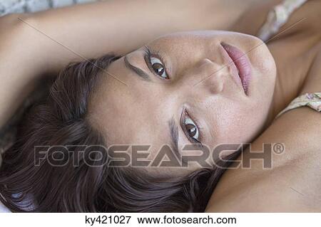 Stock Photo - Portrait of a woman lying on the bed. Fotosearch