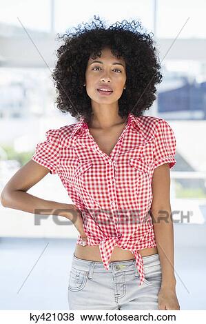 Portrait of a woman standing with her hand on her hip View Large Photo Image Stock Photo - Portrait of a woman standing with her hand on her hip. Fotosearch