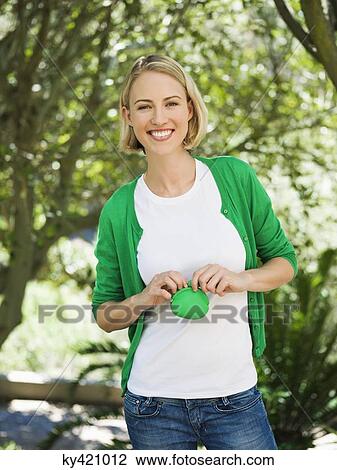 Stock Image - Smiling beautiful woman holding a pouch bag. Fotosearch