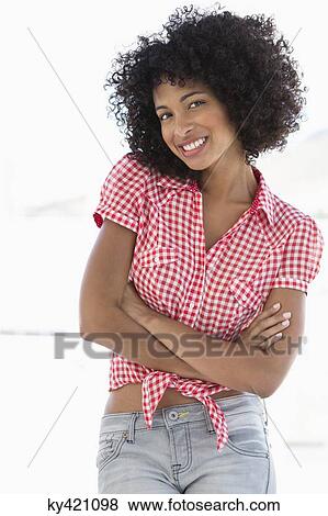 Stock Photo - Smiling woman standing with her arms crossed. Fotosearch